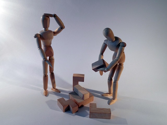 Figurines en bois en train de résoudre un casse-tête