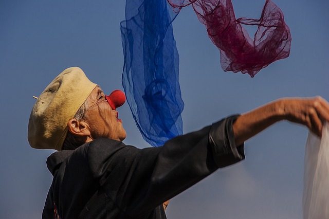 Femme clown en train de jongler avec des foulards de couleur