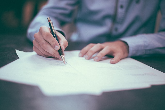 Homme en train de signer un document