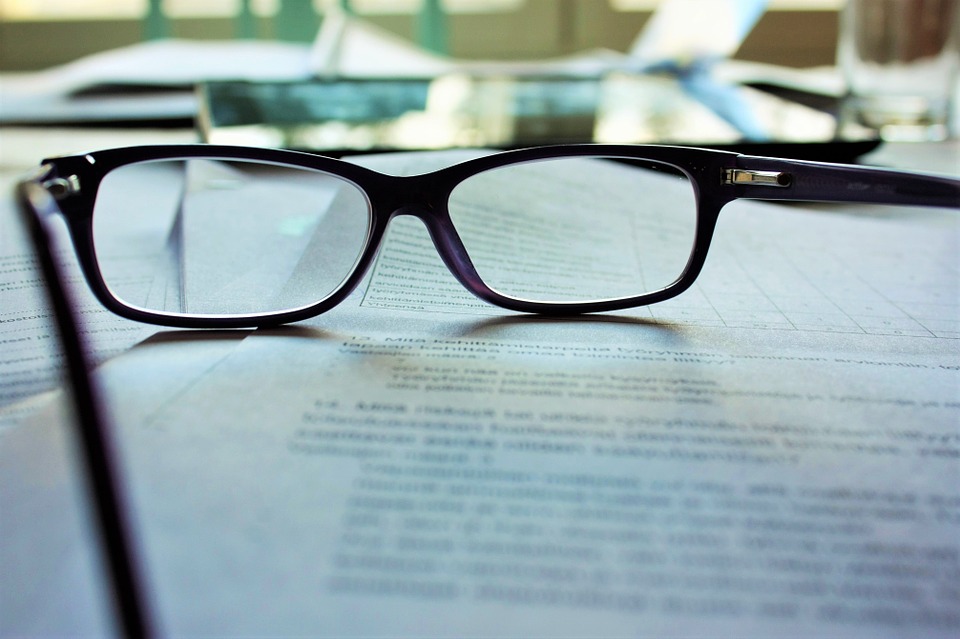 paire de lunettes posée sur un document illisible