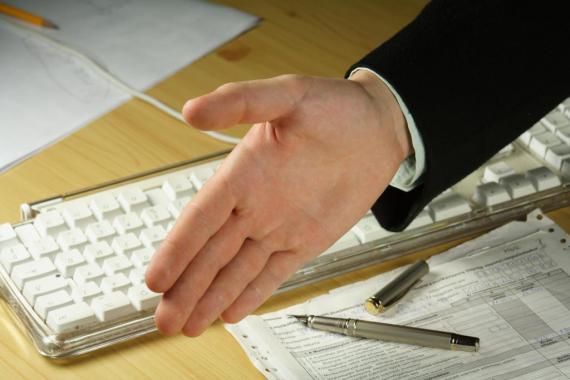 Main tendue au-dessus d'un clavier d'ordinateur