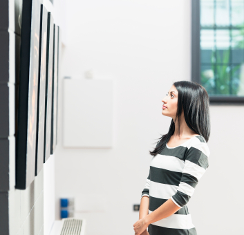 jeune femme observant une toile dans une galerie d'art