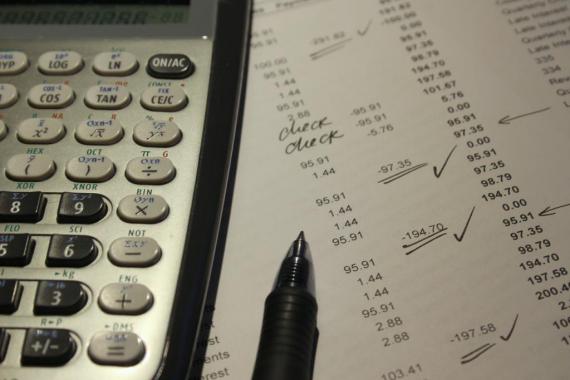 Une calculatrice et un stylo à bille posés sur un document comptable