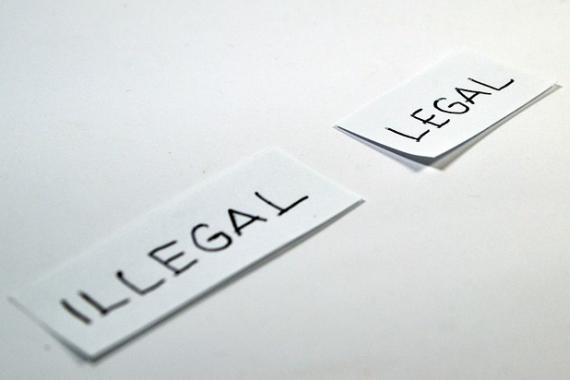 Deux morceaux de papier sur lesquels sont inscrits les mentions "illégal" et "légal"