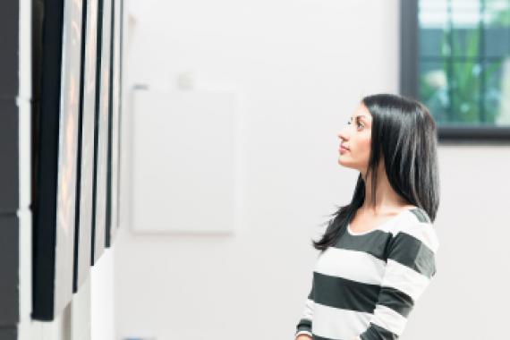 jeune femme observant une toile dans une galerie d'art