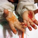 Mains d'enfant tâchées de peinture