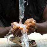 Eau coulant dans les mains d'un homme