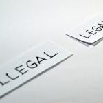 Petits papiers portant les mentions "Illegal" et "Legal" posé sur une surface plane