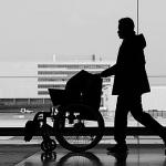 Silhouette d'un homme poussant un fauteuil roulant