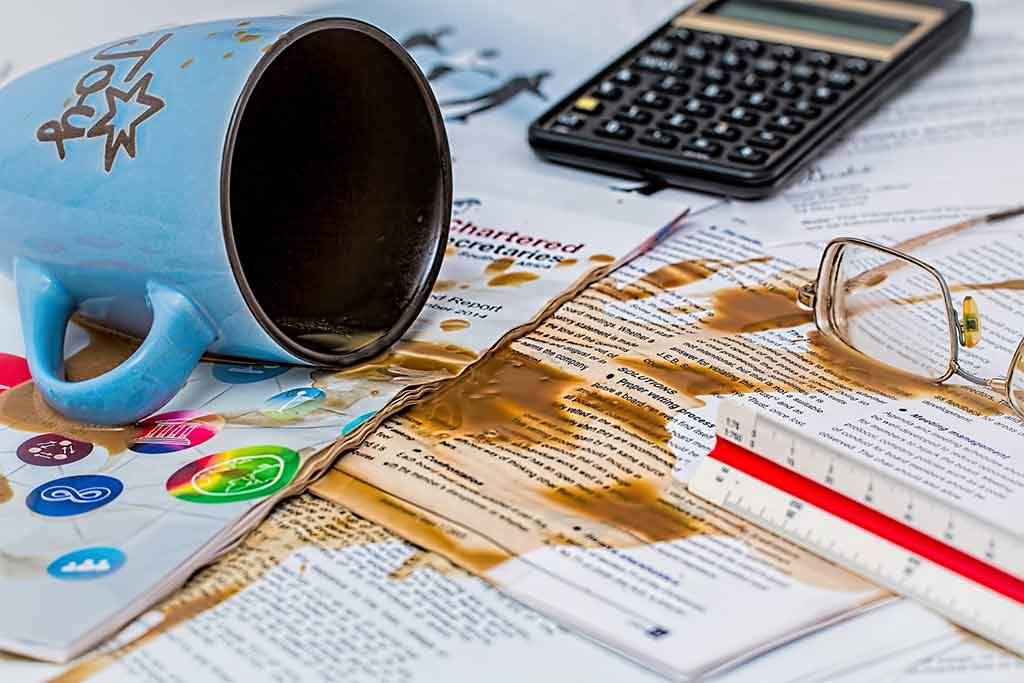 Tasse de café renversée sur un tas de feuilles éparpillées